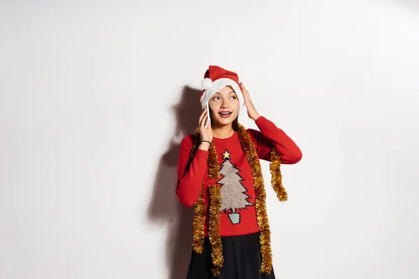 Feliz hermosa chica en una gorra roja y ropa festiva esperando el nuevo año 2018 y la Navidad —  Fotos de Stock