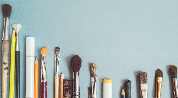 на синем фоне есть художественные кисти разных размеров
