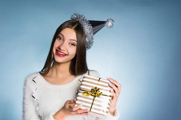 Gelukkig jong meisje heeft een cadeautje gekregen in een mooi pakket voor het nieuwe jaar — Stockfoto