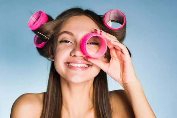 Happy νεαρό κορίτσι κάνει ένα κομψό hairstyle, στο κεφάλι μπικουτί μαλλιά, γέλια, κοιτάζει μέσα από τα σίδερα — Φωτογραφία Αρχείου