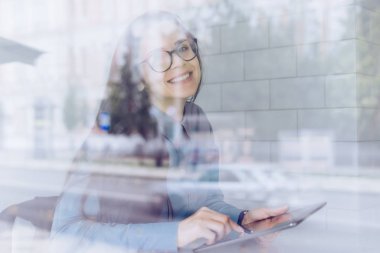 bir tablet üzerinde çalışan mutlu kız başarılı freelancer pencerenin, bir kafede oturan gözlüklü