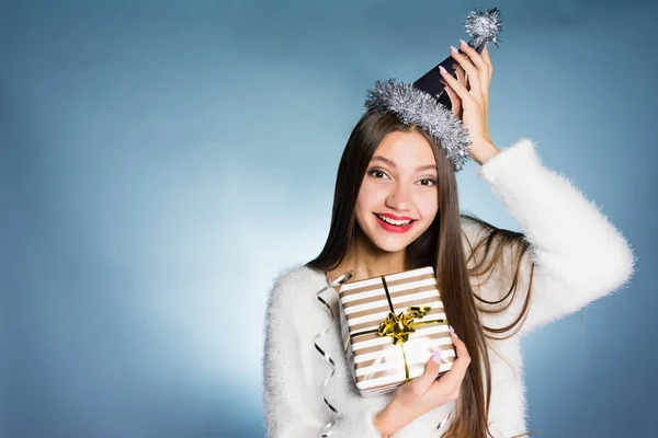 Ευτυχής χαμογελαστοί νεαρό κορίτσι σε ένα γιορτινό καπέλο έλαβε ένα δώρο για το νέο έτος από τους συναδέλφους — Φωτογραφία Αρχείου