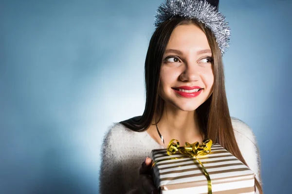 Feliz hermosa chica recibió una caja de regalo para el año nuevo de los colegas, piensa dentro — Foto de Stock