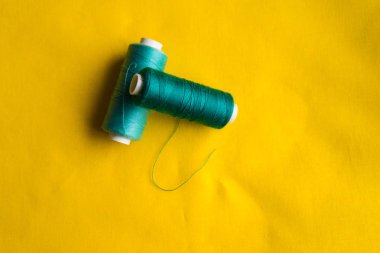 Sarı yüzeyde ile turkuaz iplik bobinleri yalan