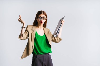 Yeşil ceket ve belgeleri holding ve sürpriz arıyor gözlük sürpriz şık genç kız