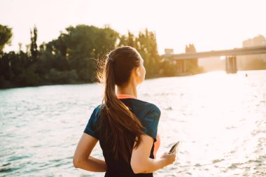 uzun saçlı genç kız nehir dolgu, güneş ışınlarının boyunca çalışır