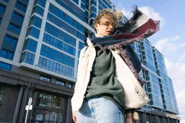 Elegante ragazza sta camminando lungo le strade della città, il vento soffia, sullo sfondo di un edificio moderno — Foto Stock