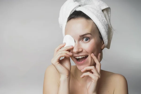 Bella donna che pulisce il viso con tampone di cotone e sorridente, Mostra tampone rotondo — Foto Stock