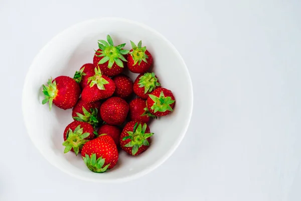 Verse rauwe gezonde voeding fruit van de aardbeien in plaat, geïsoleerd op wit, weergave boven, flatlay close-up, copyspace voor tekst, frame — Stockfoto