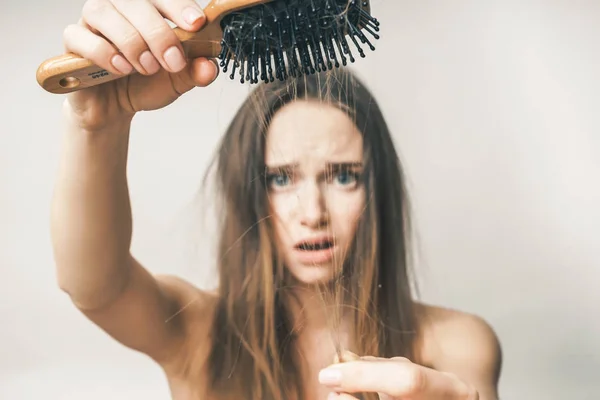 Femme avec les cheveux perdus sur peigne, problèmes, semble bouleversé — Photo