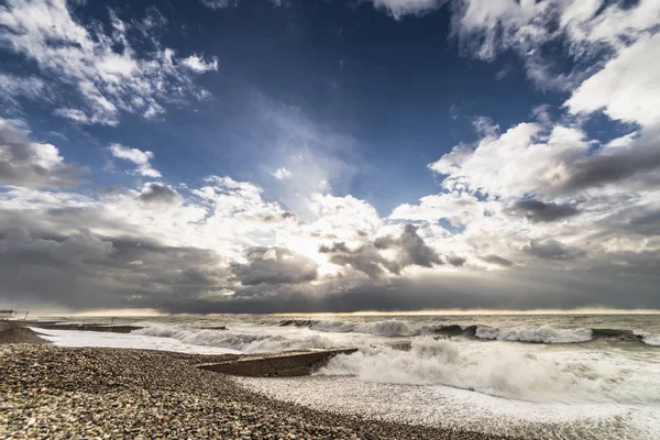 Sea, waves foaming at the beach from the pebbles, the sky is covered with clouds — Stock Photo, Image