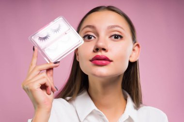 güzel genç kız onun elinde tutan bir paket ile yanlış eyelashes
