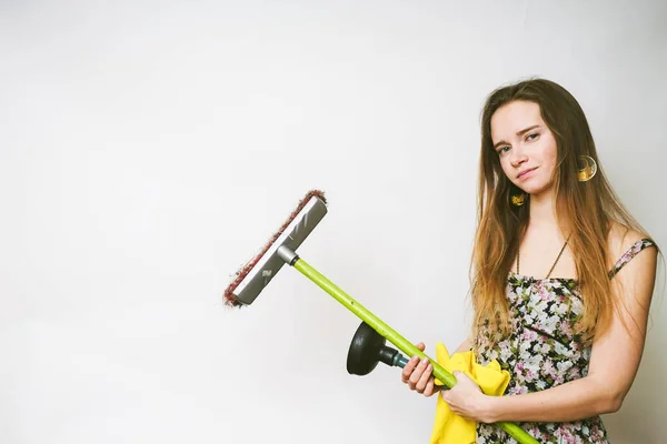 Young beautiful girl doing cleaning, on hands of yellow rubber gloves, holds a brush and plunger — Stock Photo, Image