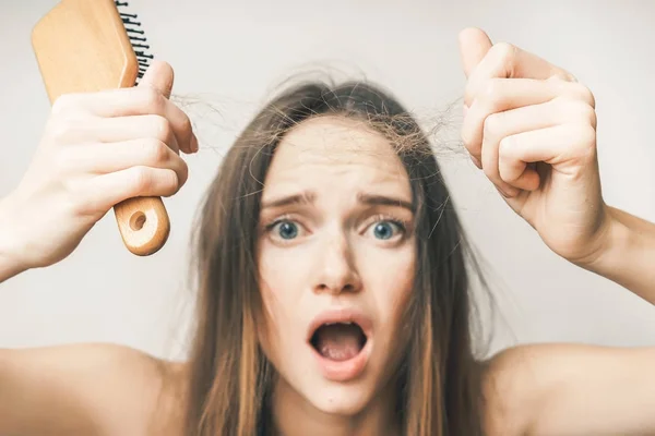 Problemas com cabelos, pente perdido, chateado e surpreso, em um fundo leve — Fotografia de Stock