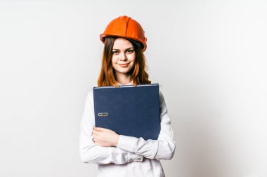 Proje dokümantasyonu turuncu bir koruyucu kask içinde mutlu genç kız tutar