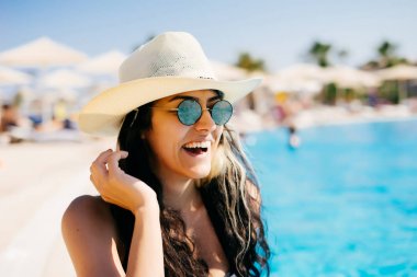 Mutlu parlayan kadın sunhat ve beach Club güneş gözlüğü