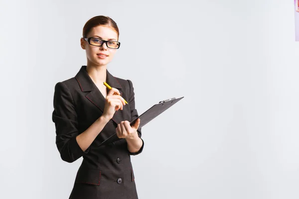 Selbstbewusste junge Geschäftsfrau mit Brille und schwarzem Anzug hält Dokumente in den Händen — Stockfoto