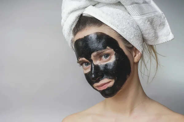 Mosolygós boldog nő alkalmazott skin care fekete mack face.moisturizer — Stock Fotó