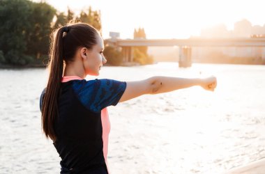 uzun saçlı atletik genç kız nehir ve güneş çerçevede eğitim açık havada önce kasları yoğurma