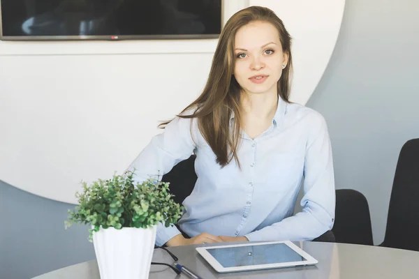 Jovem mulher bem sucedida, trabalhador de escritório, em camisa azul, sentado na mesa no escritório — Fotografia de Stock