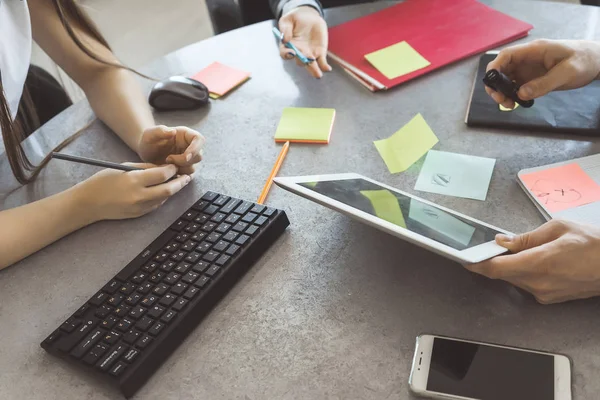 Jovem bem sucedido e meninas em ternos, trabalhadores de escritório, trabalhando juntos na mesa em um projeto — Fotografia de Stock