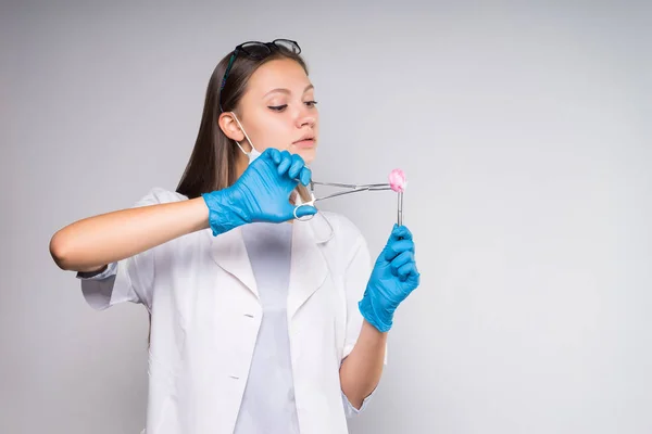 Giovane donna intelligente medico dentista tiene strumenti dentali in mano — Foto Stock