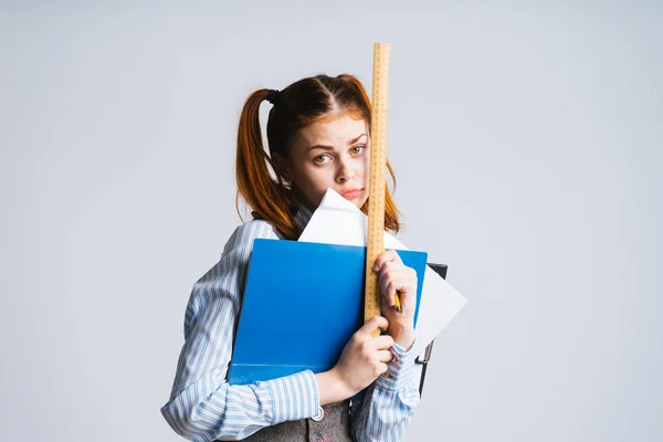 Fáradt, szomorú fiatal vörös hajú iskolás után osztály, tartja a tankönyvek és a vonalzó a kezét — Stock Fotó