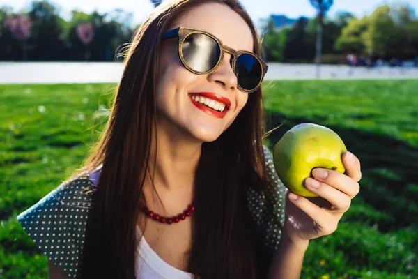 Blanqueamiento de dientes mujer muestra una sonrisa saludable, dientes, sostiene una manzana verde y sonríe — Foto de Stock