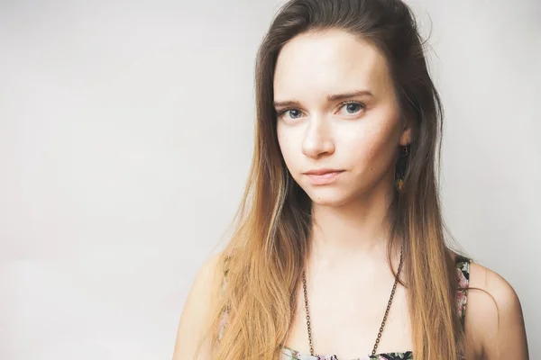 Jovem menina atraente com pele limpa e cabelos longos olha para a câmera — Fotografia de Stock