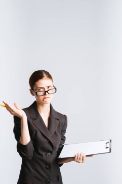 yorgun yorgun üzgün iş kadını gözlük ve sıkı bir takım belgeler belirsiz görünüyor onun elinde tutar.