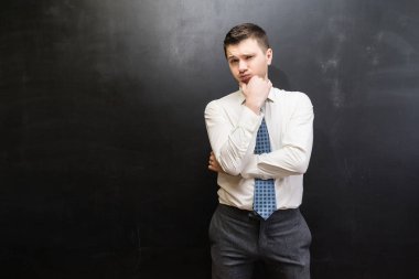 Takım, ofis çalışanı, başarılı kendine güvenen genç adam hakkında bir şey, siyah arka plan üzerine poz düşünüyorum