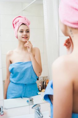 güzel genç kız kendini aynaya bakıyorum başında pembe havlu ile