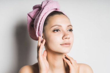 güzel genç kız başında pembe havlu ile kendini ve cildi ilgilenir