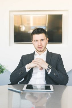 Office, masada oturan takım, ofis çalışanı, başarılı kendine güvenen genç adam tablet yalan