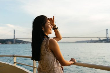 Gezi teknesinde arayan genç kız Gezgin gün batımını Uzaklik bakarak