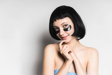 Siyah saçlı, Siyah Silikon yamalar, gözleri altında çekici kızı kameraya benziyor