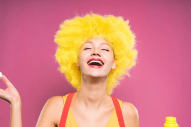 bir pembe sarı palyaço peruk takmış gülen mutlu kız