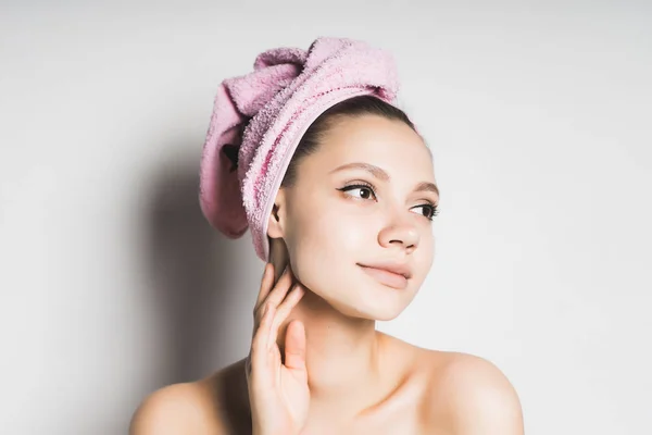 Attractive charming young girl with a pink towel on her head takes care of herself — Stock Photo, Image