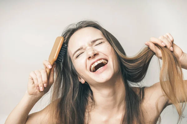 Drôle heureux adolescent profiter de poils sains, peigne en bois — Photo