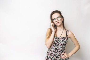 Cep telefonu, gözlük, hafif bir arka plan üzerinde konuşan kadın düşünme