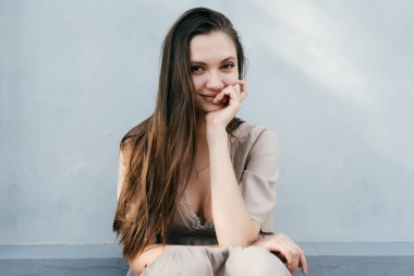 çekici parlayan genç kız model beyaz duvar çerçevede, gülümseyerek, kafasını kolunda döşeme poz