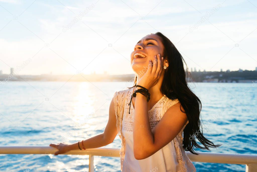 Portrait of a beautiful latin girl on a yacht at sunset and laughs, a ferry boat trip, luxury Istanbul travel