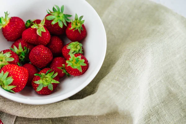 Fresas frescas crudas y saludables dieta fruta en plato, aislado en blanco, ver arriba, plano de cerca, copyspace para el texto, frame.Village lienzo rústico, comida campestre — Foto de Stock