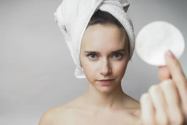 Schöne Frau reinigt ihr Gesicht mit Wattestäbchen und lächelt, zeigt runden Tupfer — Stockfoto