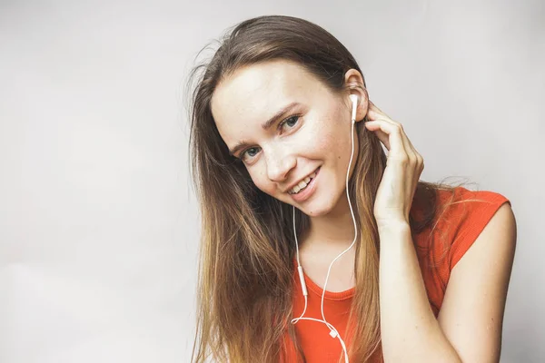 Niña sonriente escuchando música en auriculares blancos — Foto de Stock