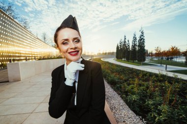 güzel ve genç birbayan hostes gülümseyen, parkta yürüyüş, beyaz eldiven giyen üniforma