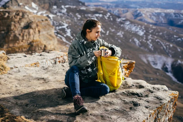 Молода мила дівчина подорожує горами, любить спортивний туризм, сидить на скелі і насолоджується сонцем — стокове фото
