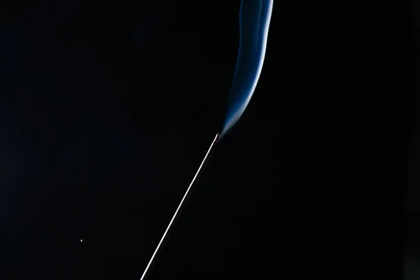 A sötét háttér parázsló füstölő kibír kék füst — Stock Fotó