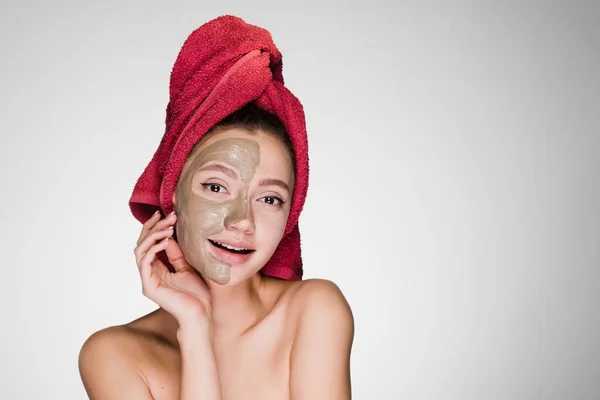 Vacker ung flicka göra spa förfarande, på halva ansiktet användbar lermask, på huvudet handduk — Stockfoto