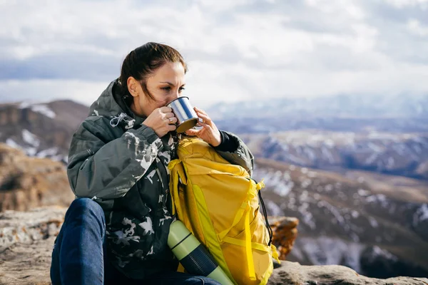 Joven activa viaja, disfruta de la naturaleza y bebe té caliente —  Fotos de Stock